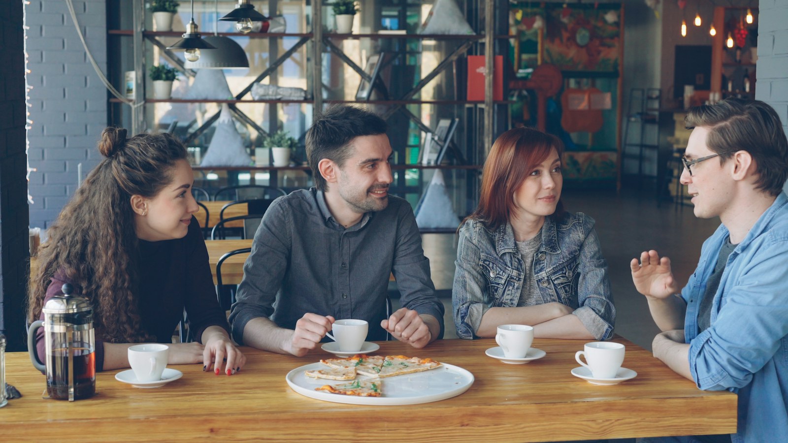 Dos personas comparten una conversación y un café.